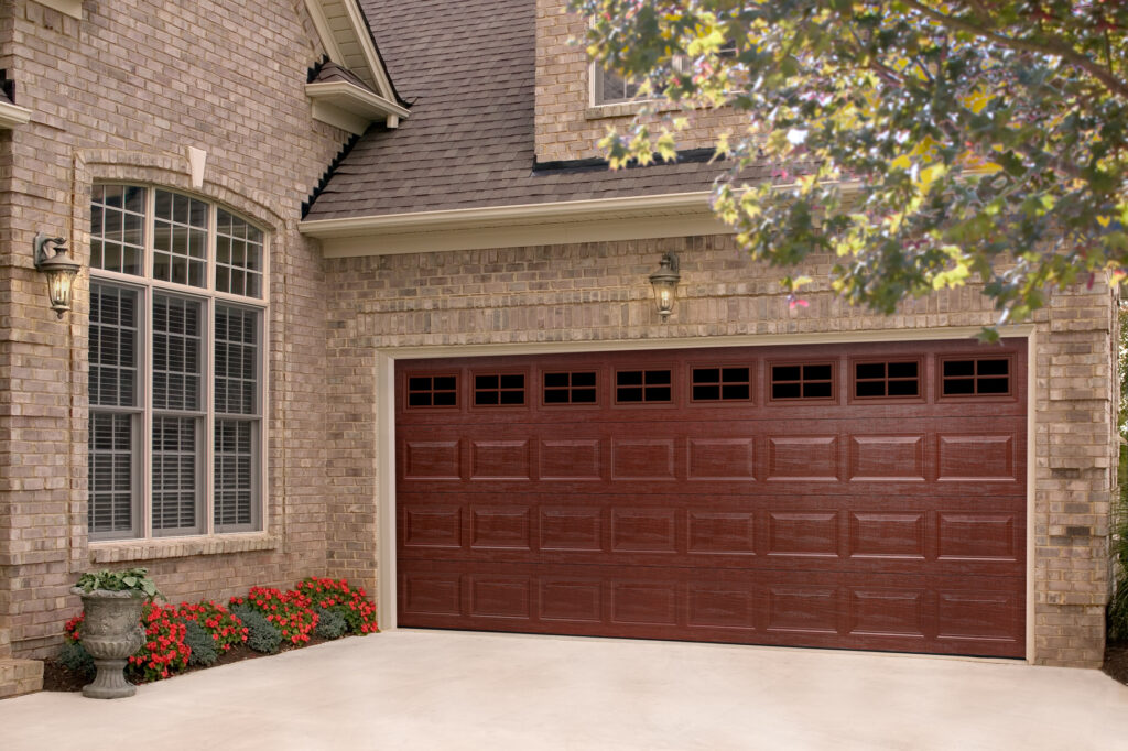 Brown steel garage door on a tan brick house