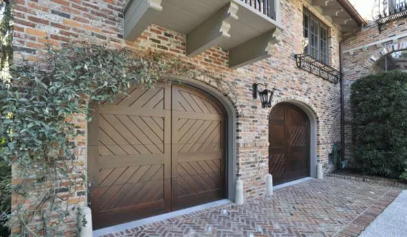 Signature carriage wood garage doors on brick house